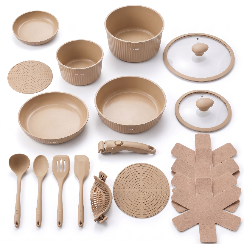 Wszystkie 20 elementów zestawu HU.KA Nestio w kolorze Dune Sand rozłożone na tle Porcelain — garnki, patelnie, szklane pokrywki, odpinana rączka, silikonowe przybory, sitko, podkładki i filcowe przekładki